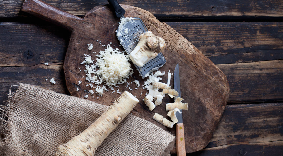 Freshly grated horseradish on a wooden cutting board