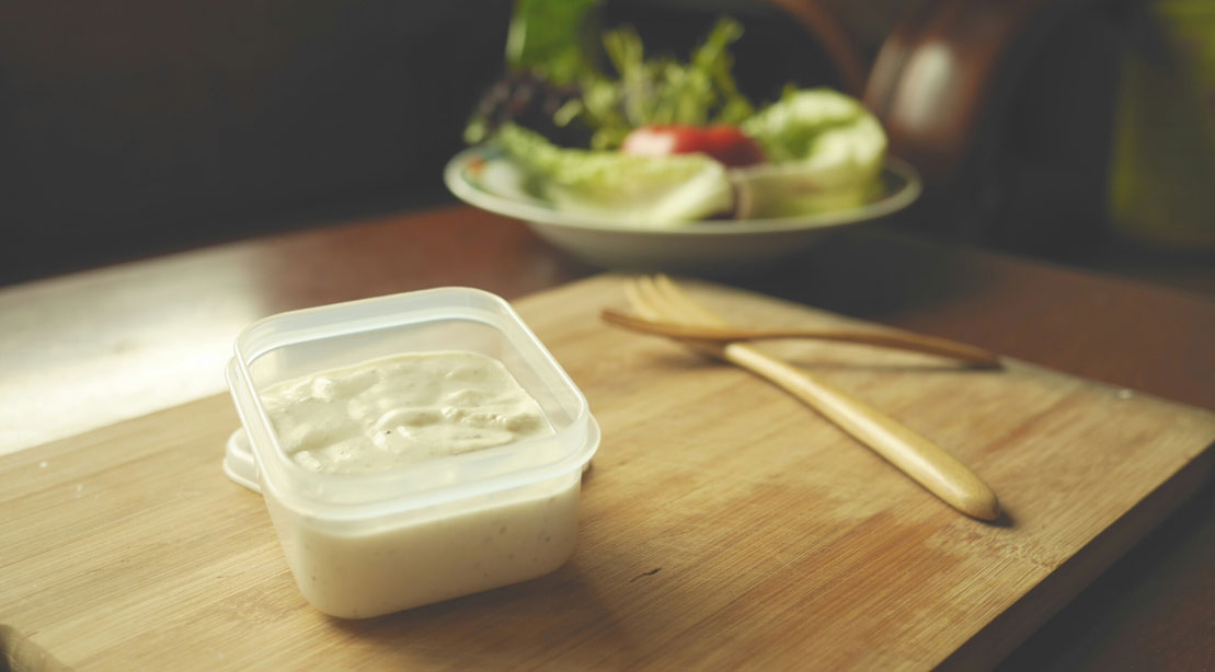 White sauce in a plastic sontainer