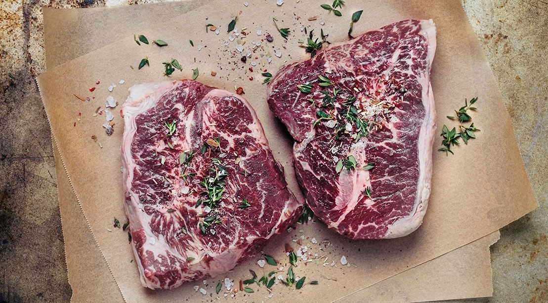 A picture of steaks resting on a table. 