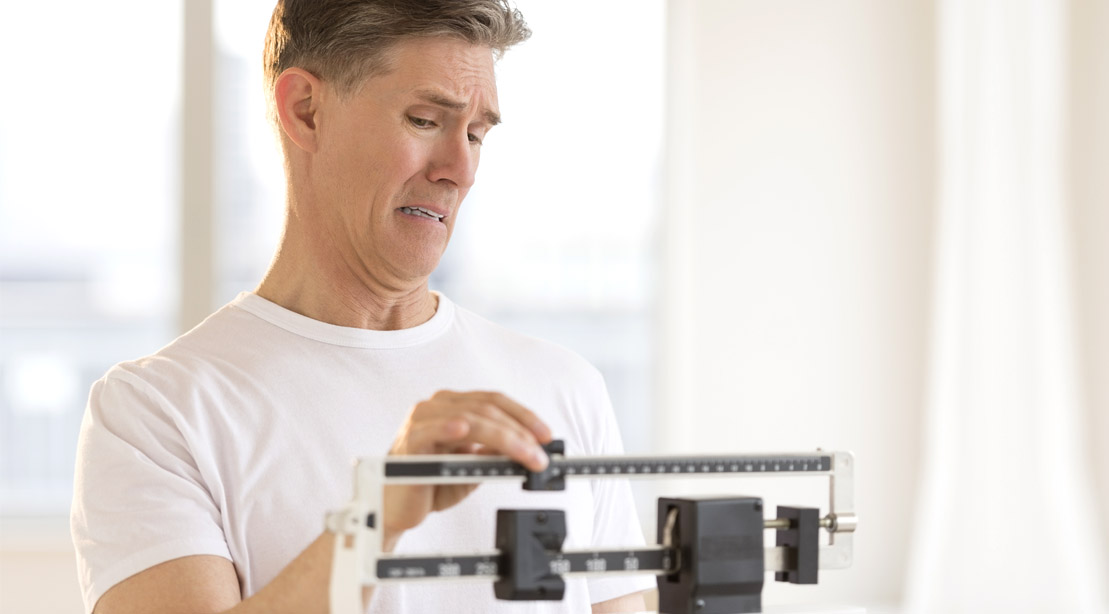 Scared older man worried at the scale