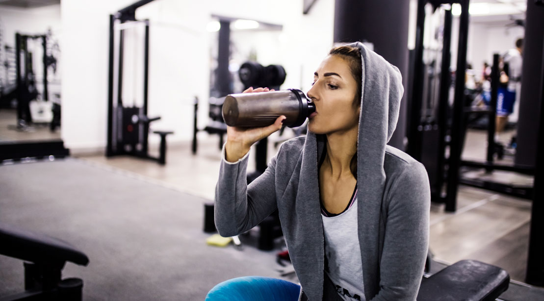 https://www.muscleandfitness.com/wp-content/uploads/2019/02/girl-with-blender-bottle-and-hoodie-681867596.jpg?w=1109&quality=86&strip=all