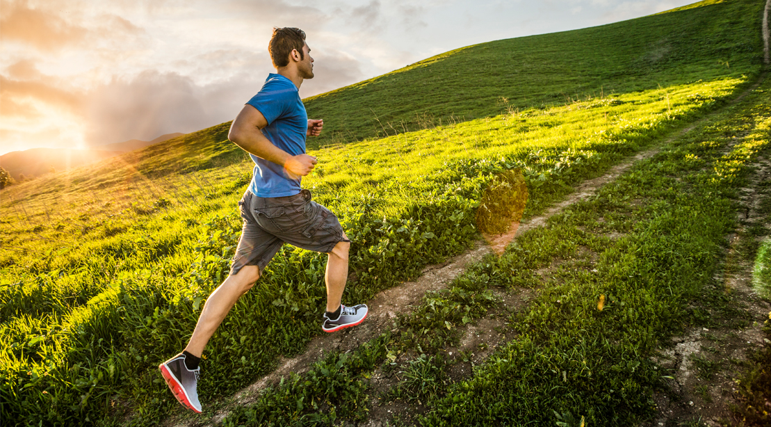 Man running up a grassy hill