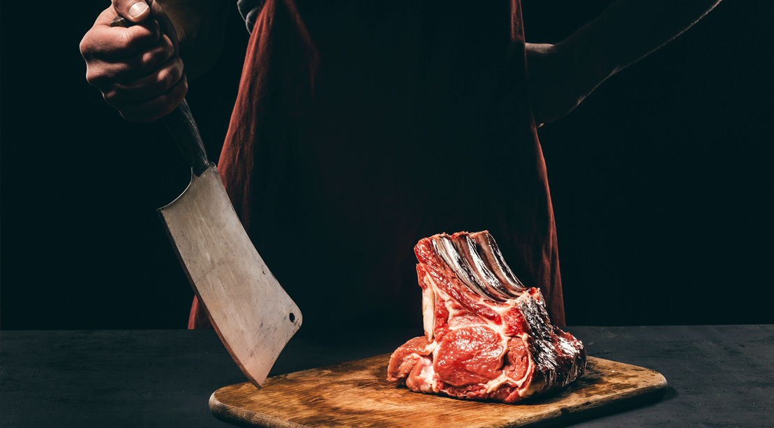 Butcher-Standing-Behind-Steak-Cuts-Cleaver.