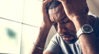 Male with his head buried in his head from being stressed and depressed due to mental health from failing his fitness resolution