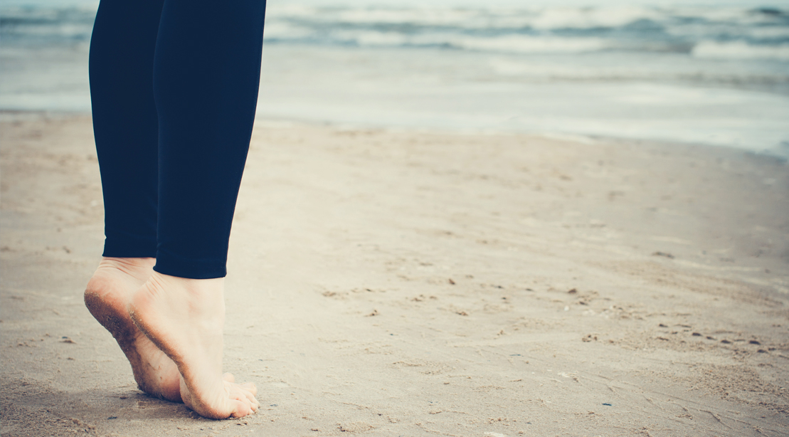 Female Doing Calf Raises On the Beach