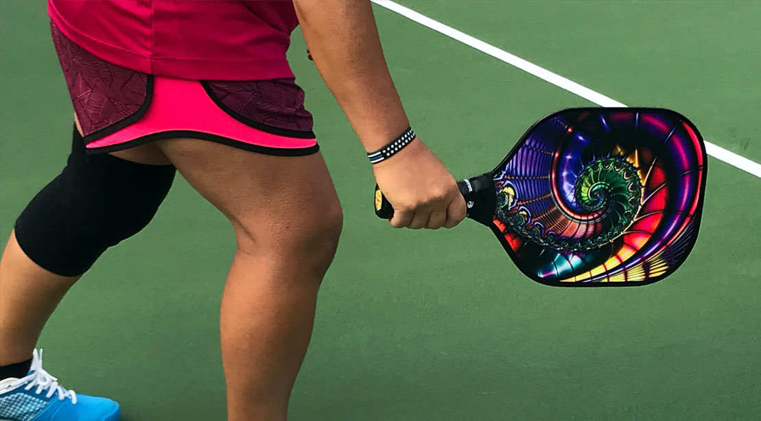 Person playing pickleball and holding a pickleball paddle