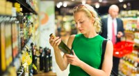 Woman shopping for olive oil and reading the olive oil label